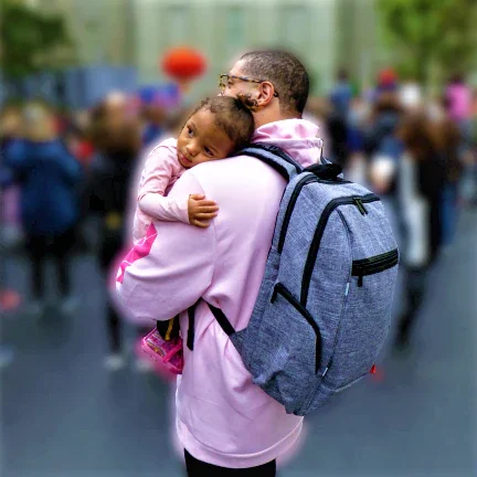 Father carrying Jaden while holding his daughter