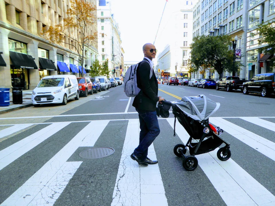 Father walking with a stroller in the city